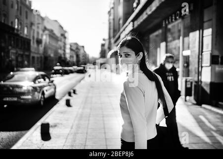 Ansioso giovane adulto colpito dal COVID-19.Walking, andando a lavorare durante pandemic.misure protettive, maschera indossare.rispettare le linee guida.evitare con Foto Stock