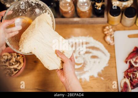 Casa moglie fare rapidamente facile pasta croccante pizza crosta fatta in casa da zero a mano.tradizionale gourmet italiano pizza base recipe.ingredienti per bak Foto Stock