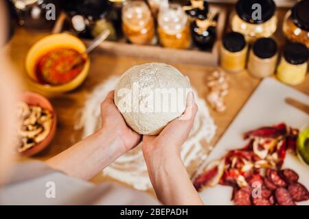 Casa moglie fare rapidamente facile pasta croccante pizza crosta fatta in casa da zero a mano.tradizionale gourmet italiano pizza base recipe.ingredienti per bak Foto Stock