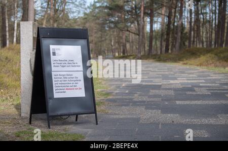 15 aprile 2020, bassa Sassonia, Bergen: Un cartello informativo nel memoriale di Bergen-Belsen vi chiede di mantenere la vostra distanza. Esattamente 75 anni fa, il 15 aprile 1945, il campo di concentramento di Bergen-Belsen fu liberato dai soldati britannici. A causa della pandemia di Corona si tratta di una commemorazione molto silenziosa: Quasi tutti i visitatori o anche i testimoni contemporanei trovano la loro strada verso l'ex campo di concentramento nel distretto di celle. Foto: Julian Stratenschulte/dpa Foto Stock