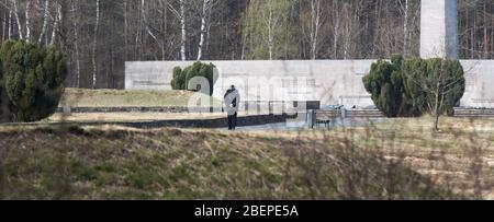 15 aprile 2020, bassa Sassonia, Bergen: Un uomo cammina attraverso il Memoriale di Bergen-Belsen. Esattamente 75 anni fa, il 15 aprile 1945, il campo di concentramento di Bergen-Belsen fu liberato dai soldati britannici. A causa della pandemia di Corona si tratta di una commemorazione molto silenziosa: Quasi tutti i visitatori o anche i testimoni contemporanei trovano la loro strada verso l'ex campo di concentramento nel distretto di celle. Foto: Julian Stratenschulte/dpa Foto Stock