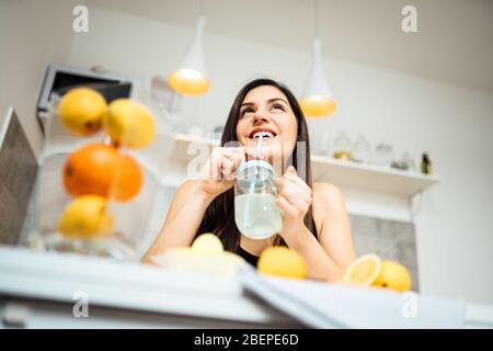 Sana donna allegra bere fatto in casa biologico misto agrumi bere.fare la dieta lemonade.Detox, nutrition.Food per la pelle oleosa, forte sistema immunitario Foto Stock