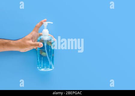 Flacone di gel igienizzante per mani per proteggere da virus e germi su sfondo blu con spazio per la copia Foto Stock