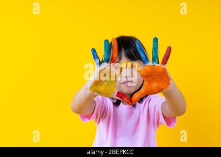 Ritratto di giovane ragazza asiatica con arte, tailandese divertente bambino mostra colore acqua su palma in forma di cuore, creatività dei bambini e l'amore pittura concetto Foto Stock