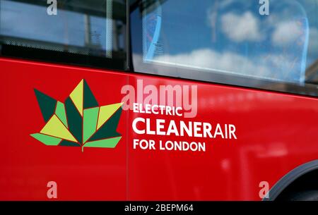 Emblema e formulazione - 'aria più pulita per Londra' - sul lato di un autobus elettrico a Londra. Con le nuvole bianche e morbide riflesse nella finestra. Foto Stock