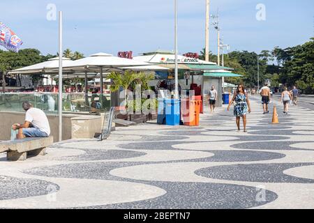 Persone che camminano sul viale Copacabana con il tipico modello di piastrelle portoghesi e riaperto chiosco durante l'epidemia del virus Corona COVID-19 Foto Stock
