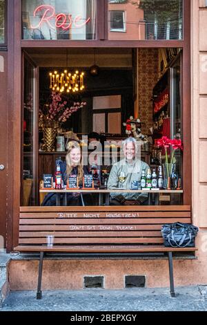 Berlino, Mite. Il personale serve cibo e bevande da asporto attraverso la finestra del ristorante Zur Rose durante la pandemia COVID-19 non sedersi sulla panchina Foto Stock