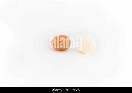 un uovo di pollo marrone e un uovo bollito e sbucciato Foto Stock