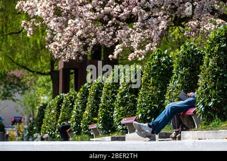 Passau, Germania. 15 aprile 2020. Poche persone si siedono al lungomare della locanda e godono il sole. Credit: Armin Weigel/dpa/Alamy Live News Foto Stock