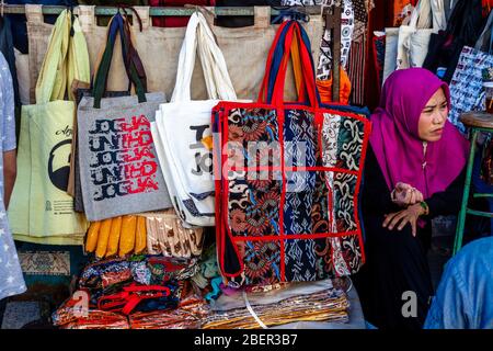 Una donna vende borse di souvenir fuori DA un negozio in Malioboro Street, Yogyakarta, Java, Indonesia. Foto Stock