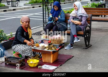 Una donna indonesiana che vende spuntini a Malioboro Street, Yogyakarta, Indonesia. Foto Stock