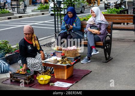 Una donna indonesiana che vende spuntini a Malioboro Street, Yogyakarta, Indonesia. Foto Stock