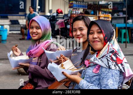 Giovani indonesiani Donne che mangiano cibo di strada, Malioboro Street, Yogyakarta, Indonesia. Foto Stock