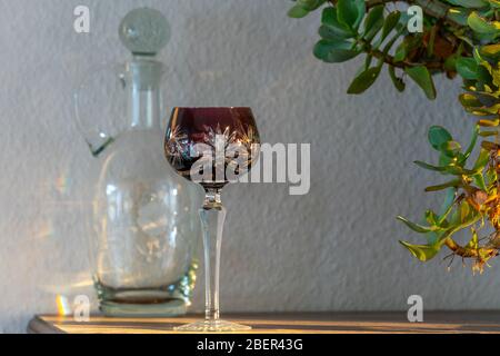 Vetro e decanter antichi rossi di vino bohémien su armadio Foto Stock