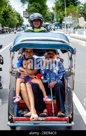 Una famiglia indonesiana che viaggia in taxi, Yogyakarta, Java, Indonesia. Foto Stock