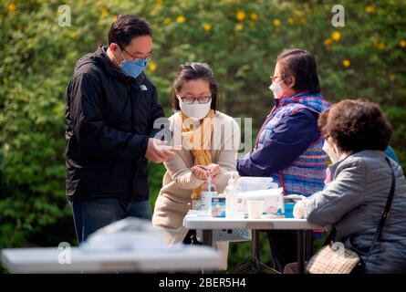 Elezioni generali della Corea del Sud, 15 aprile 2020 : gli elettori usano i disinfettanti a mano quando arrivano in una stazione di scrutinio per le elezioni generali del 15 aprile a Seoul, Corea del Sud. Le elezioni quadrenarie riempiranno l’Assemblea nazionale unicamerale della Corea del Sud, che ha 300 seggi. Per prevenire l'infezione da coronavirus COVID-19, agli elettori è stato chiesto di stare a distanza di almeno 1 metro l'uno dall'altro presso le stazioni di raccolta. Si è consigliato di indossare maschere facciali, controllare la loro temperatura e sono stati lasciati a gettare le schede dopo aver utilizzato disinfettanti per le mani e indossando guanti di plastica. Foto Stock