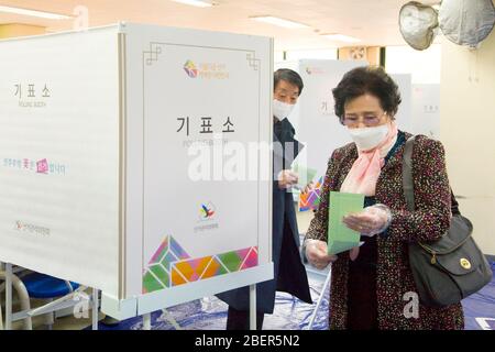 Elezioni generali della Corea del Sud, 15 aprile 2020 : gli elettori sudcoreani hanno votato in una stazione di votazione per le elezioni generali del 15 aprile a Seoul, Corea del Sud. Le elezioni quadrenarie riempiranno l’Assemblea nazionale unicamerale della Corea del Sud, che ha 300 seggi. Per prevenire l'infezione da coronavirus COVID-19, agli elettori è stato chiesto di stare a distanza di almeno 1 metro l'uno dall'altro presso le stazioni di raccolta. Si è consigliato di indossare maschere facciali, controllare la loro temperatura e sono stati lasciati a gettare le schede dopo aver utilizzato disinfettanti per le mani e indossando guanti di plastica. Foto Stock