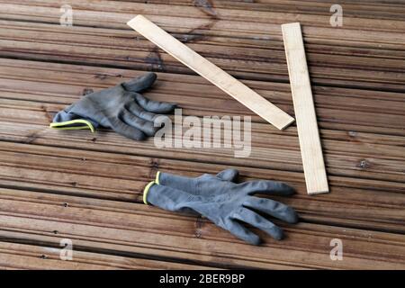 Fai da te costruzione di un portico / balcone pavimento con tavole di legno marrone a Espoo, Finlandia, febbraio, 2020. In questa foto potete vedere il pavimento e i guanti Foto Stock