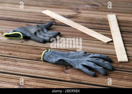 Fai da te costruzione di un portico / balcone pavimento con tavole di legno marrone a Espoo, Finlandia, febbraio, 2020. In questa foto potete vedere il pavimento e i guanti Foto Stock