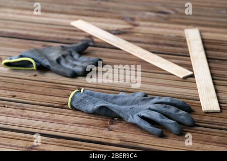 Fai da te costruzione di un portico / balcone pavimento con tavole di legno marrone a Espoo, Finlandia, febbraio, 2020. In questa foto potete vedere il pavimento e i guanti Foto Stock