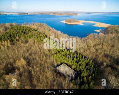 Vista aerea di bunker in cemento armato apparteneva alla sede delle forze terrestri tedesche della seconda guerra mondiale nascosta in una foresta sulla riva del lago Mitry, Mamerki Foto Stock