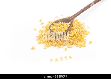 Mucchio di pasta a forma di lettera in un cucchiaio di legno isolato su sfondo bianco Foto Stock