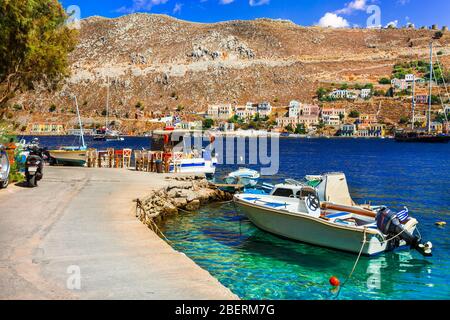 Taverna tradizionale, barche da pesca e case sull'isola di Symi, Grecia. Foto Stock