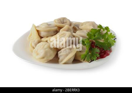 Gnocchi bolliti con kerrup e un rametto di coriandolo su un piatto isolato su bianco Foto Stock