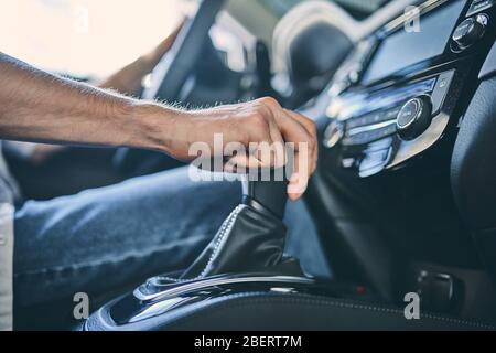 Mano maschio che tiene in primo piano il cambio. Foto Stock