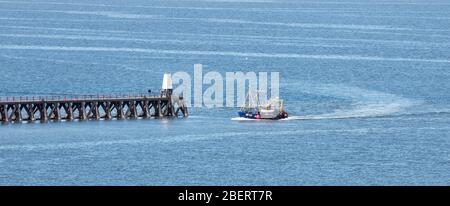 Una barca da pesca che ritorna al porto di Maryport in Cumbria Foto Stock