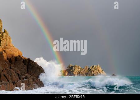 Arcobaleno sopra Logan Rock, Porthcurno Foto Stock