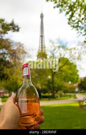 Parigi, Francia - 9 APRILE 2019: Torre di Eifel vista da un'angolazione diversa. Mano con una bottiglia di vino, Parigi, Francia Foto Stock