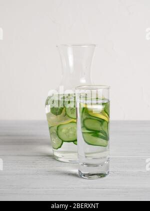 Vaso con cetrioli, fette di lime e menta all'interno per ricetta di acqua detox di cetrioli di limone. Concetto di detox fatto in casa. Verticale Foto Stock