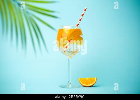 Estate Detox bere su uno sfondo blu. Bevanda fredda estiva con arance e ghiaccio su fondo colorato vuoto. Foto Stock