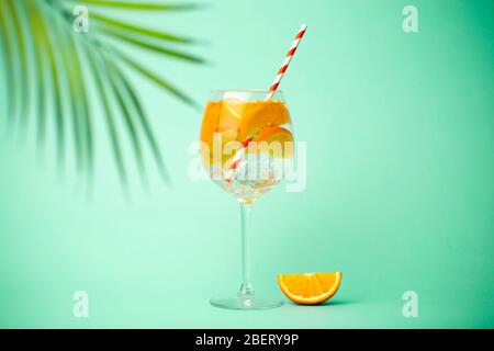 Estate Detox bere su uno sfondo blu. Bevanda fredda estiva con arance e ghiaccio su fondo colorato vuoto. Foto Stock