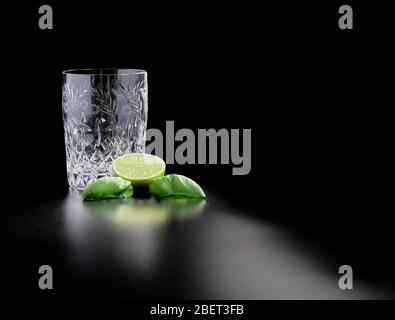 Bicchiere di cristallo per cocktail fatti in casa con lime basilico Foto Stock