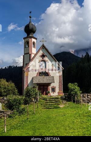 Vista della Chiesa di San Giovanni, Santa Maddalena con le Dolomiti di Puez-Geisler alle spalle Foto Stock