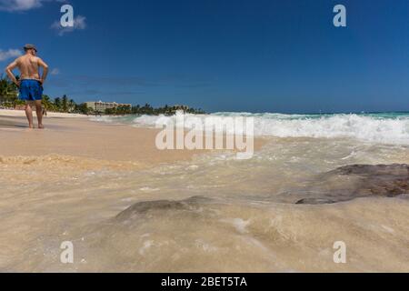 Uomo in piedi sulla spiaggia affacciata sul mare Foto Stock