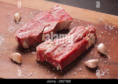 Bistecca di manzo salato su un tavolo di legno Foto Stock