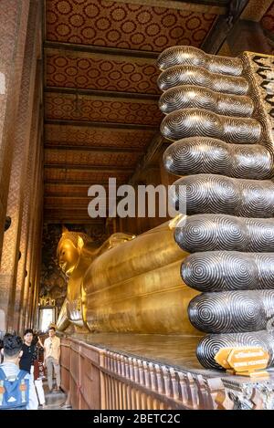 Bangkok, Thailandia - 29 Febbraio 2020: Turistica di fronte alla gigantesca statua dorata del buddha reclinato, Bangkok, Thailandia. Foto Stock