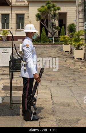 Bangkok, Thailandia - 29 febbraio 2020: Un soldato che custodisce il grande palazzo, tiene una pistola e indossa una maschera. Foto Stock