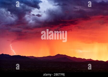 Fulmine sciopero da una tempesta monsonica al tramonto nelle montagne del deserto vicino Tucson, Arizona Foto Stock