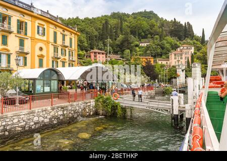 VARENNA, LAGO DI COMO, ITALIA - 2019 GIUGNO: Molo dei traghetti e edifici sul lago a Varenna sul Lago di Como. Foto Stock