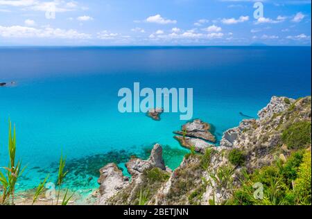 Vista panoramica aerea dell'orizzonte e delle incredibili acque turchesi blu tropicali del mare, roccia scogliera collina erba, piattaforma Parco Belvedere Capo Vaticano Foto Stock