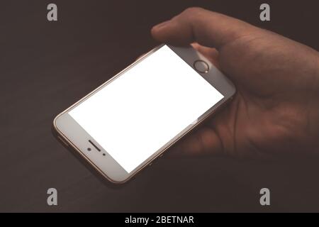 Primo piano della mano maschile e utilizzo di uno smartphone moderno con schermo vuoto per il testo o il contenuto Foto Stock
