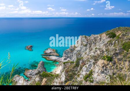 Vista panoramica aerea dell'orizzonte e delle incredibili acque turchesi blu tropicali del mare, roccia scogliera collina erba, piattaforma Parco Belvedere Capo Vaticano Foto Stock