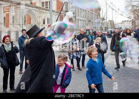 Street performer che soffia bolle di sapone giganti Foto Stock