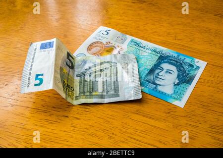 Nuova banconota da cinque sterline, in cima alla banconota da cinque euro Foto Stock
