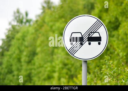 Segnale di traffico fine del divieto di sorpasso in autostrada suburbana Foto Stock