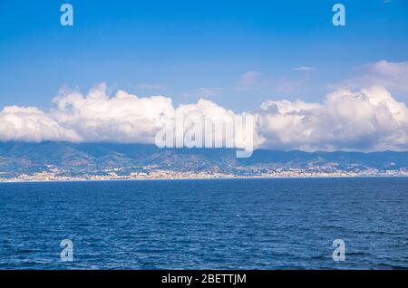 Stretto di Messina collegante Mediterraneo e Tirreno mare e Sicilia isola con cielo blu e bianco nuvole sfondo, vista dal lungomare Quay wa Foto Stock